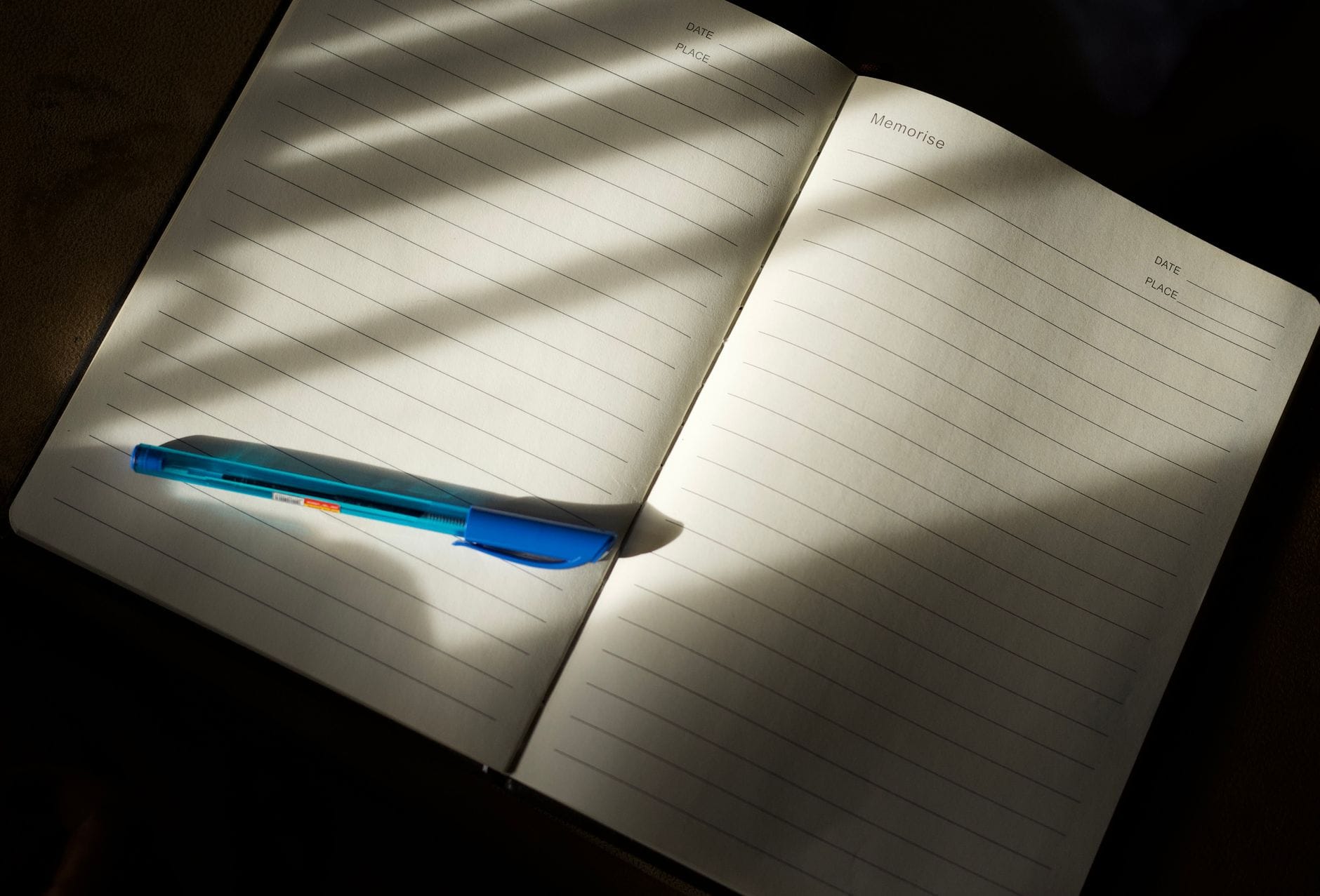 Un agenda papier ouvert sur un bureau, un stylo posé sur la page de la semaine.